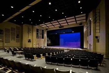 a large auditorium with rows of chairs in front of a stage